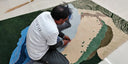 artisan working on a colorful hand-tufted wool rug