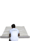 man rolling tufted wool rug