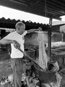 A man dyeing yarn in a traditional setting