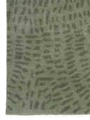 tufted green wool rug corner close up