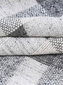 Close-up of handwoven textured gray and white rugs
