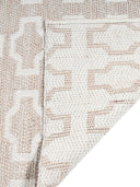 Close-up of a textured beige and white rug with a geometric pattern.