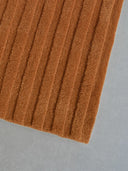 tufted brown rug corner
