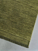 green handloom carpet with frayed edge